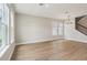 Bright living room with large windows and modern light fixture illuminating the warm, wood-look flooring at 16460 Silver Brook Way, Winter Garden, FL 34787