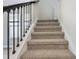 Carpeted staircase with black wrought iron railing and white risers with natural light at 16460 Silver Brook Way, Winter Garden, FL 34787