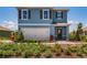 Charming two-story home with blue exterior, brown shutters, and well-manicured landscaping at 1654 Badger Creek Rd, Kissimmee, FL 34744