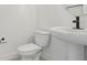 Small half bath featuring a floating sink and toilet, and neutral color scheme at 16544 Silver Brook Way, Winter Garden, FL 34787