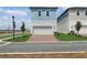 Two-story home featuring a brick driveway, a two-car garage, and a manicured lawn at 16544 Silver Brook Way, Winter Garden, FL 34787