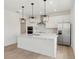 Bright modern kitchen with stainless steel appliances, white cabinetry, and a large center island at 16544 Silver Brook Way, Winter Garden, FL 34787