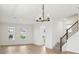 Bright living room featuring a modern light fixture, staircase, and natural light at 16544 Silver Brook Way, Winter Garden, FL 34787