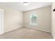 Standard bedroom with beige carpet, light-colored walls, and a window for natural lighting at 1774 Peterson Pl, Sanford, FL 32773