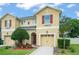 Two-story tan home featuring a front yard with a tree and a single-car garage at 1774 Peterson Pl, Sanford, FL 32773