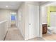Hallway with carpet leading to bedrooms and a bathroom with a brown vanity at 1774 Peterson Pl, Sanford, FL 32773