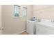 Functional laundry room with a washer, dryer, shelving, and natural light from the window at 1774 Peterson Pl, Sanford, FL 32773