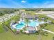 Aerial view of community amenities, showcasing a large pool, palm trees, lounge chairs, and outdoor seating at 1834 Waggoner St, Kissimmee, FL 34744