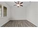 Clean, empty room with wood floors, white walls, a modern ceiling fan, and a bright window at 19204 Paddock St, Orlando, FL 32833