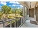 Covered front porch featuring white railings and views of the landscaped front yard and mature trees at 19204 Paddock St, Orlando, FL 32833