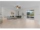 Bright living room featuring neutral tile floors, a ceiling fan, and sliding glass doors to an enclosed lanai at 19204 Paddock St, Orlando, FL 32833