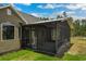 Rear exterior view of the home featuring an attached screened patio and landscaped yard at 19204 Paddock St, Orlando, FL 32833