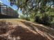 Backyard landscape, showing large trees and a slope in the yard. Enjoy nature and privacy in the spacious backyard at 2120 Lakebreeze Way, Deltona, FL 32738