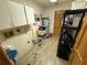 Functional laundry room featuring cabinets, utility sink, water heater, shelving and vinyl flooring at 2120 Lakebreeze Way, Deltona, FL 32738