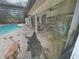 Patio view through dirty screen, showing the pool and lounge area with a dog visible at 2120 Lakebreeze Way, Deltona, FL 32738