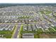 Aerial view showcasing the layout of a well-maintained community with uniform gray roofed homes at 2241 Mystic Maze Ln, Minneola, FL 34715