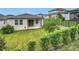 A view of the backyard showcasing the home's exterior, green lawn, and a fence ensuring privacy at 2241 Mystic Maze Ln, Minneola, FL 34715