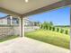 Covered patio overlooking a spacious, well-maintained backyard, enhanced with sturdy retaining walls and lush landscaping at 2241 Mystic Maze Ln, Minneola, FL 34715