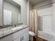 Bathroom with granite counters, single sink, tub with shower and wood-look tile floor at 2241 Mystic Maze Ln, Minneola, FL 34715