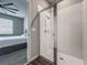 Bathroom featuring glass-enclosed shower, bedroom view in the distance with ceiling fan and plush carpet at 2241 Mystic Maze Ln, Minneola, FL 34715