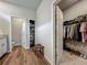 Bathroom with wood tile flooring, storage closet, toilet room, walk-in closet with shelving and clothing racks at 2241 Mystic Maze Ln, Minneola, FL 34715