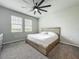 Bright bedroom featuring a ceiling fan, neutral walls, plush carpet and natural light from two windows at 2241 Mystic Maze Ln, Minneola, FL 34715