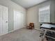 Bedroom with neutral walls, plush carpet, a desk and chair, closet with sliding doors and natural light at 2241 Mystic Maze Ln, Minneola, FL 34715