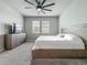 Spacious bedroom with a ceiling fan, two windows, a large bed and carpet flooring at 2241 Mystic Maze Ln, Minneola, FL 34715