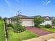 Charming single-Gathering home with a two-car garage, landscaped yard, and a beautiful red brick driveway at 2241 Mystic Maze Ln, Minneola, FL 34715