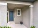 Covered front porch with a blue front door, small window, and pot for flowers at 2241 Mystic Maze Ln, Minneola, FL 34715