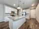 Spacious kitchen features white cabinets, stainless steel appliances, and a large center island with granite countertops at 2241 Mystic Maze Ln, Minneola, FL 34715