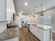 Modern kitchen with stainless steel appliances, white cabinetry, granite countertops and wood flooring at 2241 Mystic Maze Ln, Minneola, FL 34715