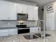 Close up of kitchen details including granite countertops, tile backsplash, and stainless steel appliances at 2241 Mystic Maze Ln, Minneola, FL 34715