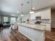 Open-concept kitchen with granite island, stainless steel appliances, white cabinets and hardwood floors at 2241 Mystic Maze Ln, Minneola, FL 34715