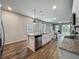 Bright, open kitchen features stainless steel appliances, an island with a sink, and wood-look tile flooring at 2241 Mystic Maze Ln, Minneola, FL 34715