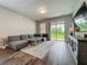Cozy living room with modern furniture, wood-look tile, and sliding glass doors leading to the backyard at 2241 Mystic Maze Ln, Minneola, FL 34715