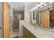 Well-lit bathroom featuring double sinks, marble countertops, and a walk-in shower with sliding barn doors at 2415 S Oak Ave, Sanford, FL 32771