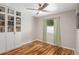 Cozy bedroom featuring hardwood floors, a ceiling fan, and built-in shelving for ample storage at 2415 S Oak Ave, Sanford, FL 32771