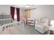 Bright Bedroom featuring a crib, changing table, accent chair, and a sliding barn door at 2415 S Oak Ave, Sanford, FL 32771