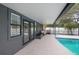 A covered patio adjoins the pool area, creating a comfortable space to relax at 2415 S Oak Ave, Sanford, FL 32771