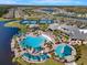 Gorgeous aerial view of the community pool with lounge seating, umbrellas and tennis courts at 2458 Cliff Way, St Cloud, FL 34771