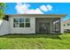 Green backyard featuring screened lanai with sliding glass doors; perfect for outdoor enjoyment at 2458 Cliff Way, St Cloud, FL 34771