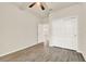 Bright bedroom with wood-look flooring and a ceiling fan, features double doors to closet and hallway at 2458 Cliff Way, St Cloud, FL 34771