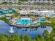 Scenic aerial shot of the community pool overlooking a lake with a fountain and lush landscaping at 2458 Cliff Way, St Cloud, FL 34771