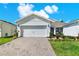 Charming home with brick-paved driveway, manicured lawn, and a white two-car garage at 2458 Cliff Way, St Cloud, FL 34771