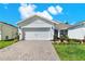 Charming home featuring a two-car garage, well-manicured lawn, and a beautifully paved driveway on a sunny day at 2458 Cliff Way, St Cloud, FL 34771