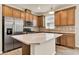 Modern kitchen with an island, stainless steel appliances, and wood cabinets at 2458 Cliff Way, St Cloud, FL 34771