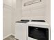 Well-lit laundry room with modern white washer and dryer, and wire shelving for storage at 2458 Cliff Way, St Cloud, FL 34771
