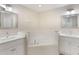 Bright bathroom featuring a large soaking tub, double vanity, and updated fixtures at 2755 Abbey Ave, Orlando, FL 32833
