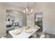 Elegant dining area featuring modern chandelier and table setting, with a view into a cozy living space at 2755 Abbey Ave, Orlando, FL 32833